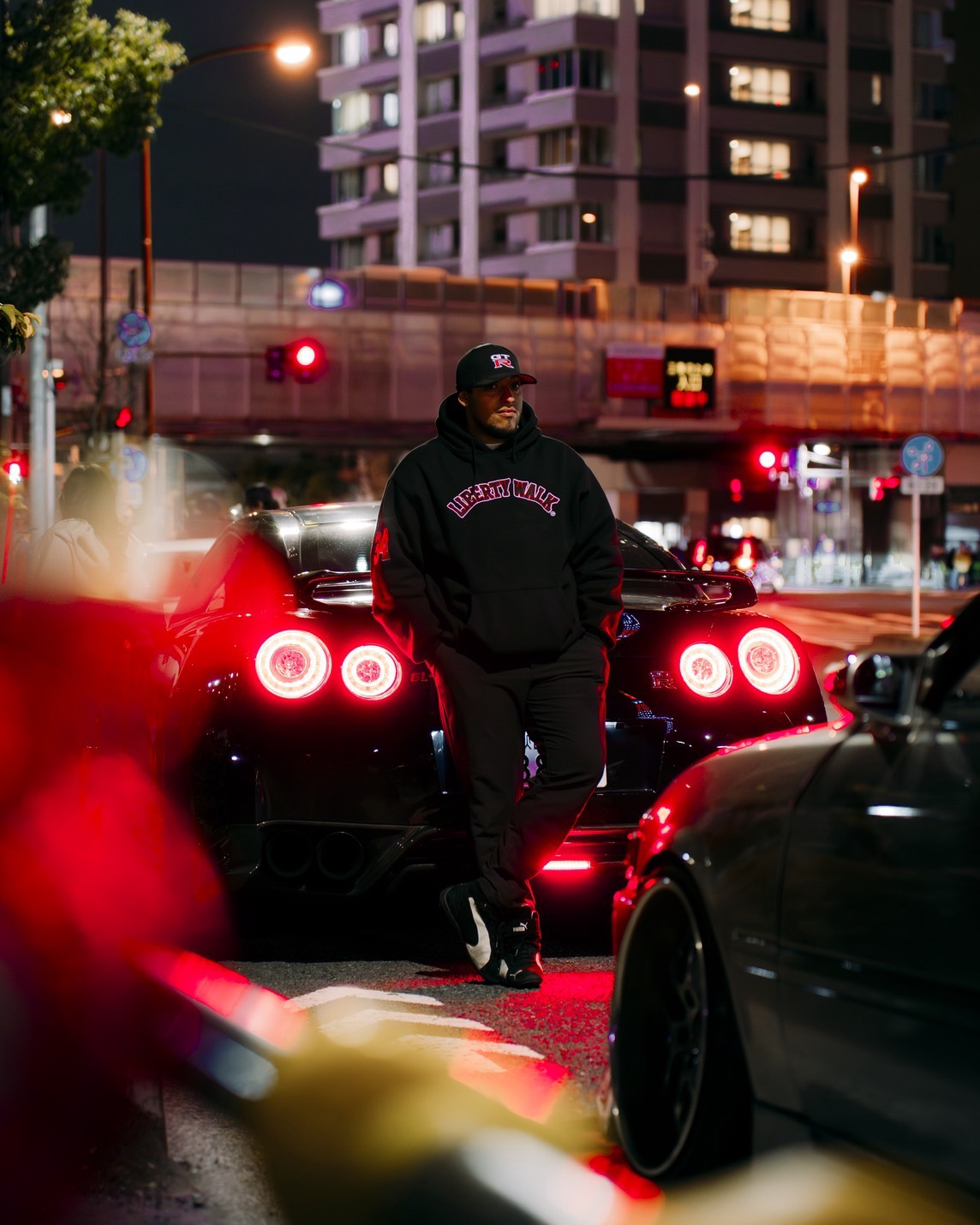 San - Your Driver & Guide standing with GT-R at night